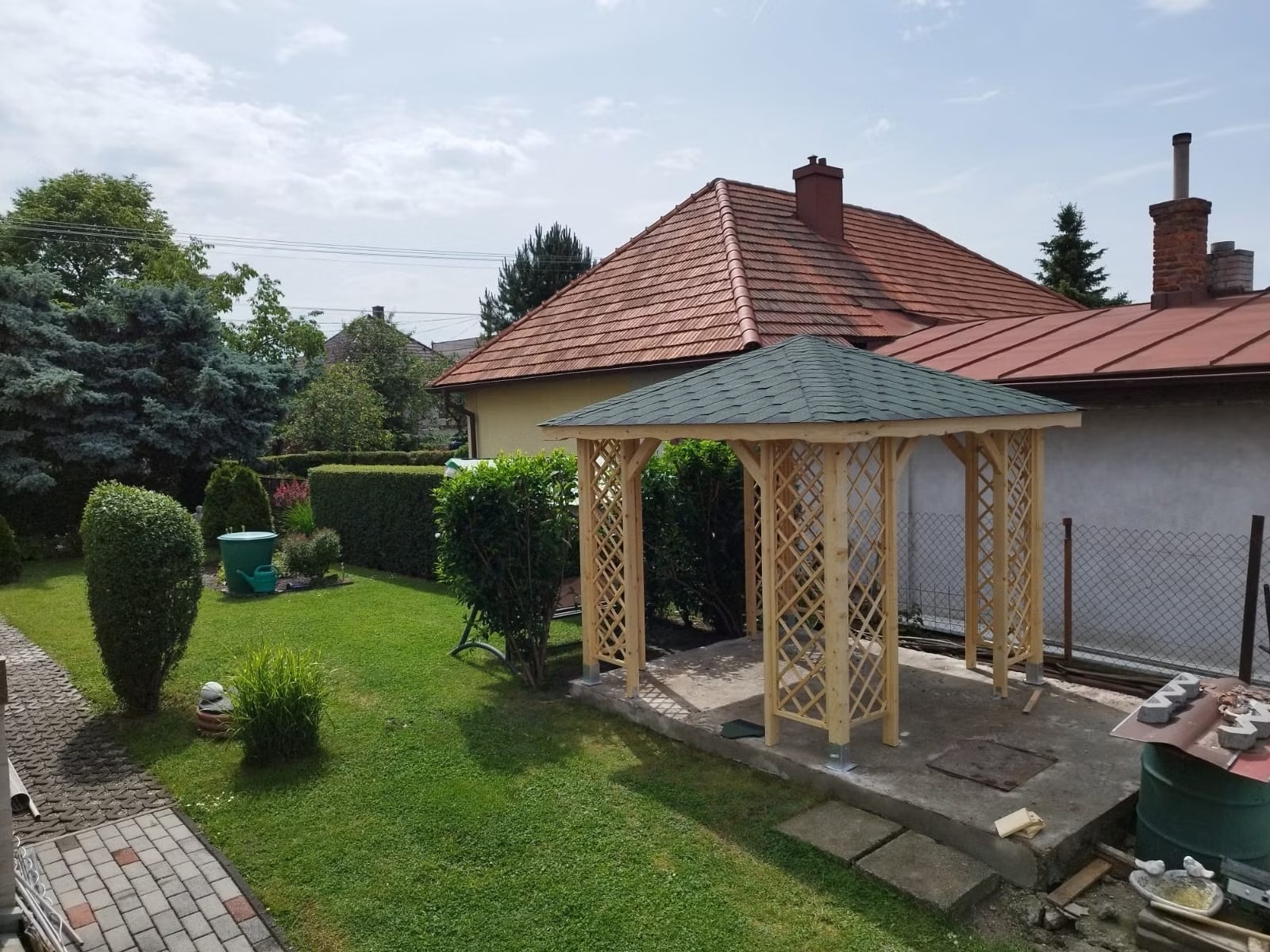 Záhradný altánok Start I z dreva s otvoreným rámom, susedí s okrasnou zeleňou a kvetinami